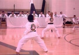 Emmons Taekwondo - A group of people practicing karate in a gymnasium at a TaeKwonDo Academy.